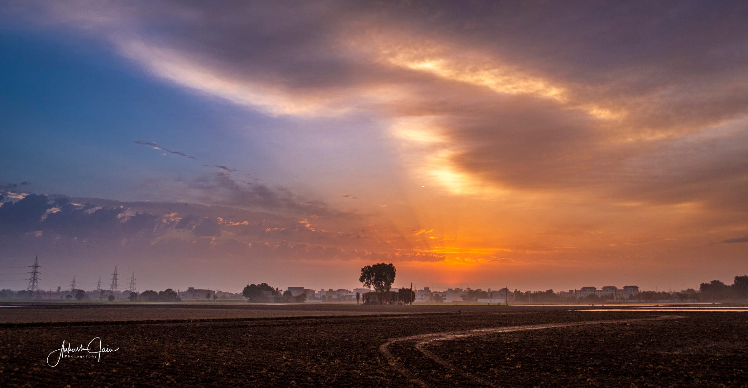 Crepuscular rays over a freshly-tilled field at dawn, along the South City bypass near Jainpur