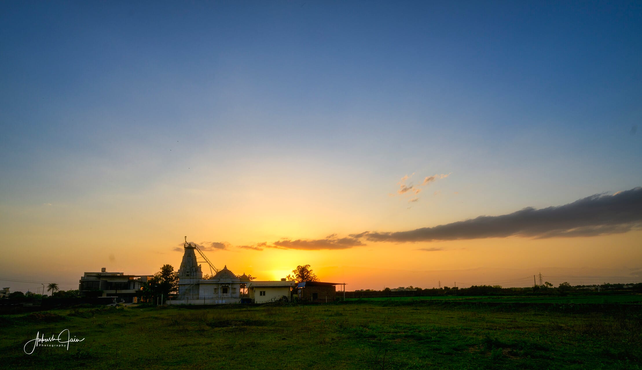Jain temple at Mahaveer Enclave silhouetted against a sunset sky, Ludhiana