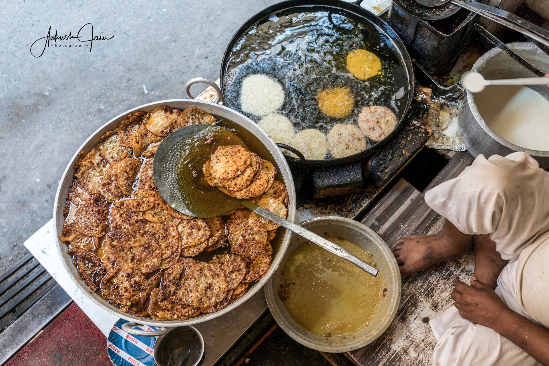 Vendor frying malpua in a huge kadhai, Pushkar