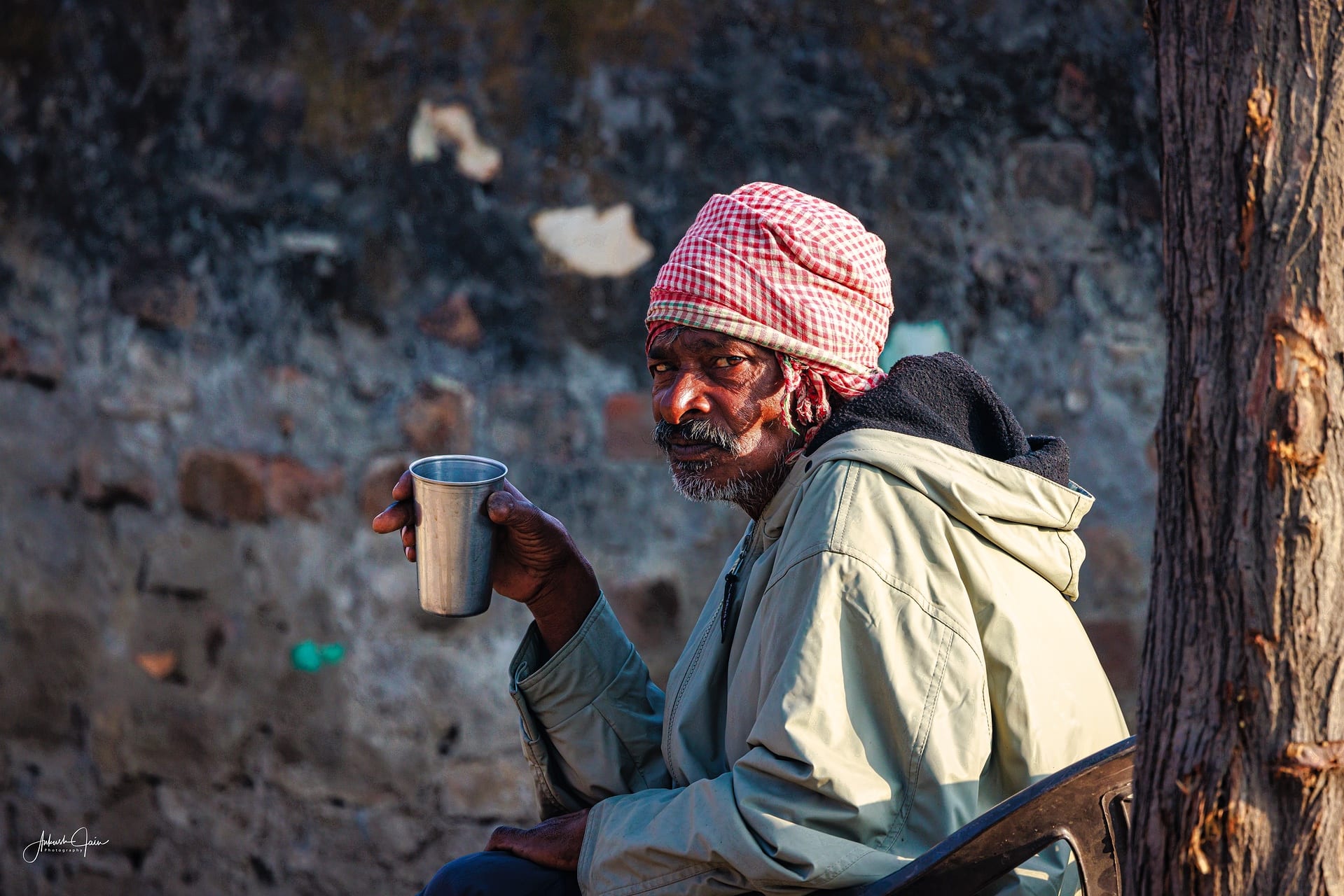 Labourer in a checked turban with a steel cup of tea, near the banks of the Satluj at Khaira Bet