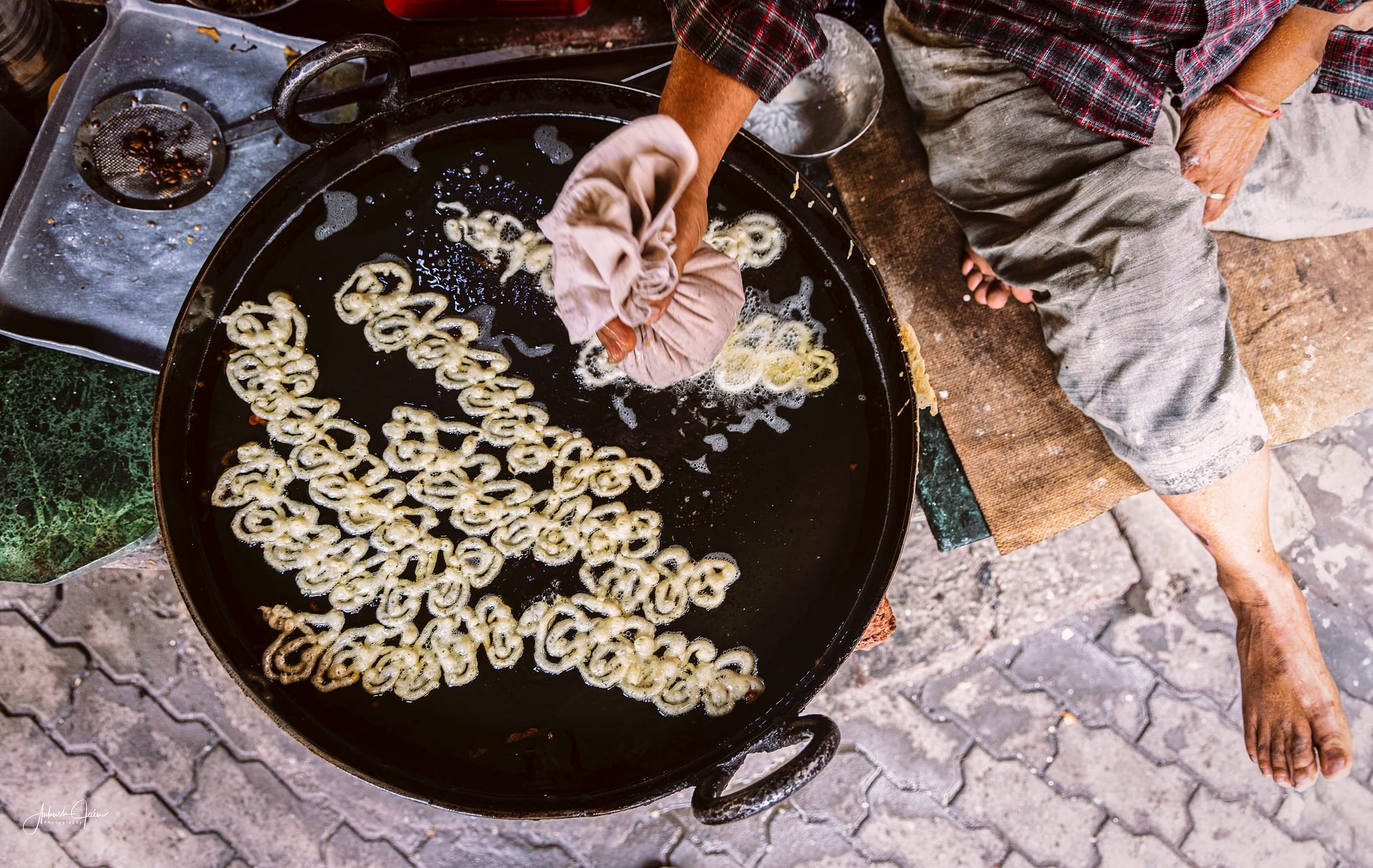 Vendor frying jalebis in a black kadhai on the street, Amritsar