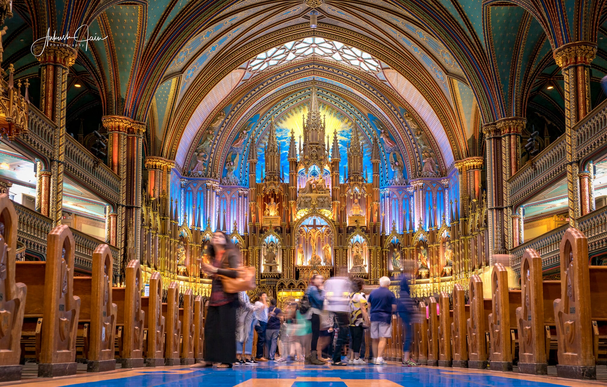 Inside Notre-Dame Basilica, Montreal — gold-and-blue vaulted altar, visitors blurred in long exposure