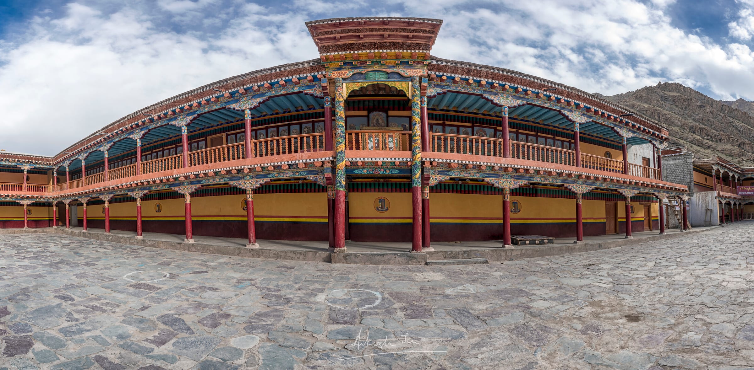 Wide panorama of the painted courtyard galleries at Hemis monastery