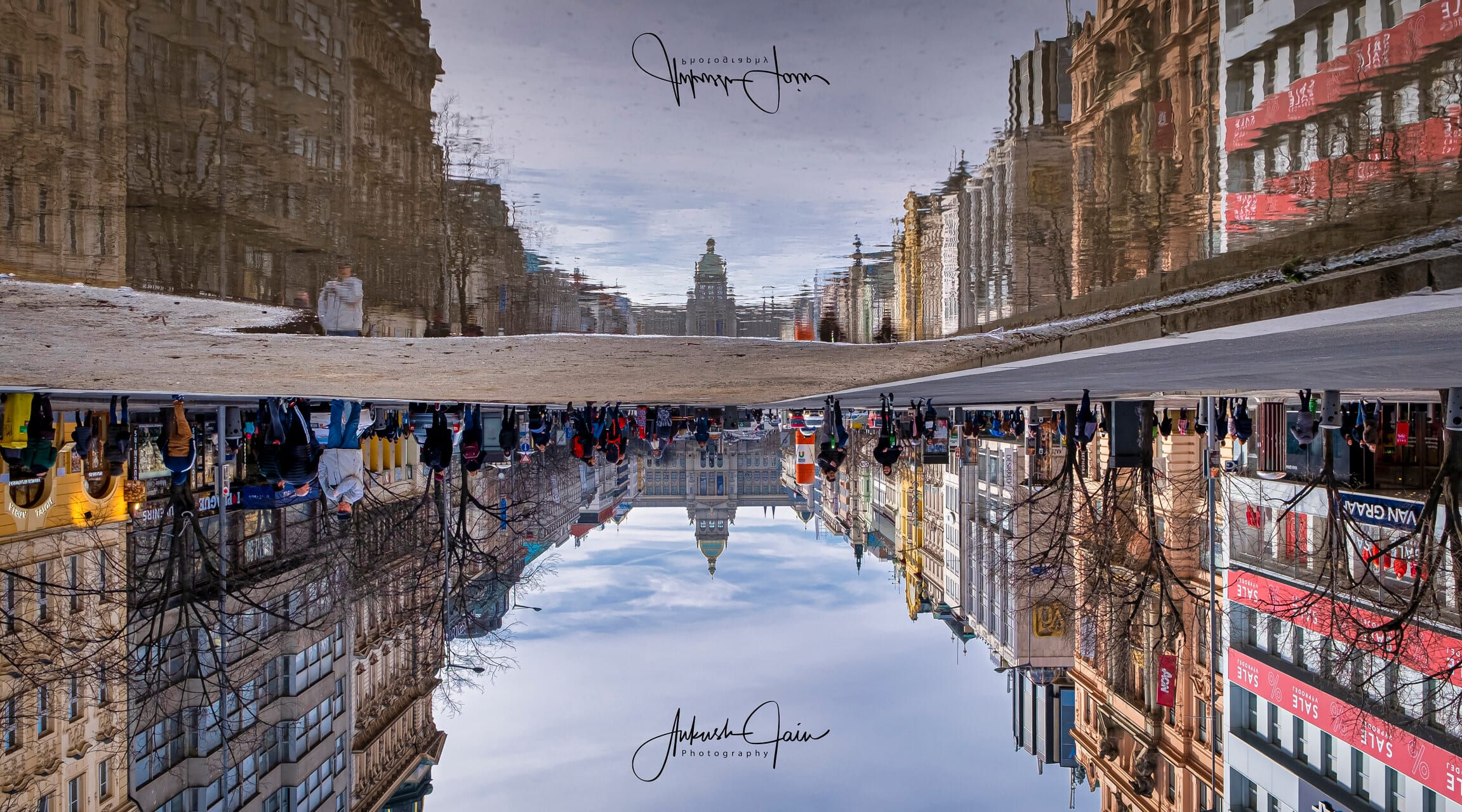 Upside-down puddle reflection of Wenceslas Square, the National Museum dome at the far end