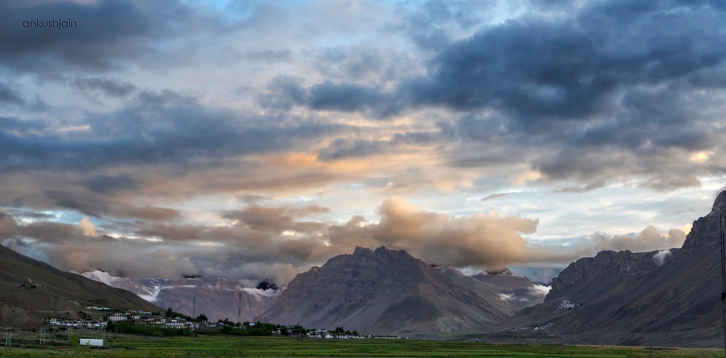 A small village settled in a valley floor, ringed by bare brown hills