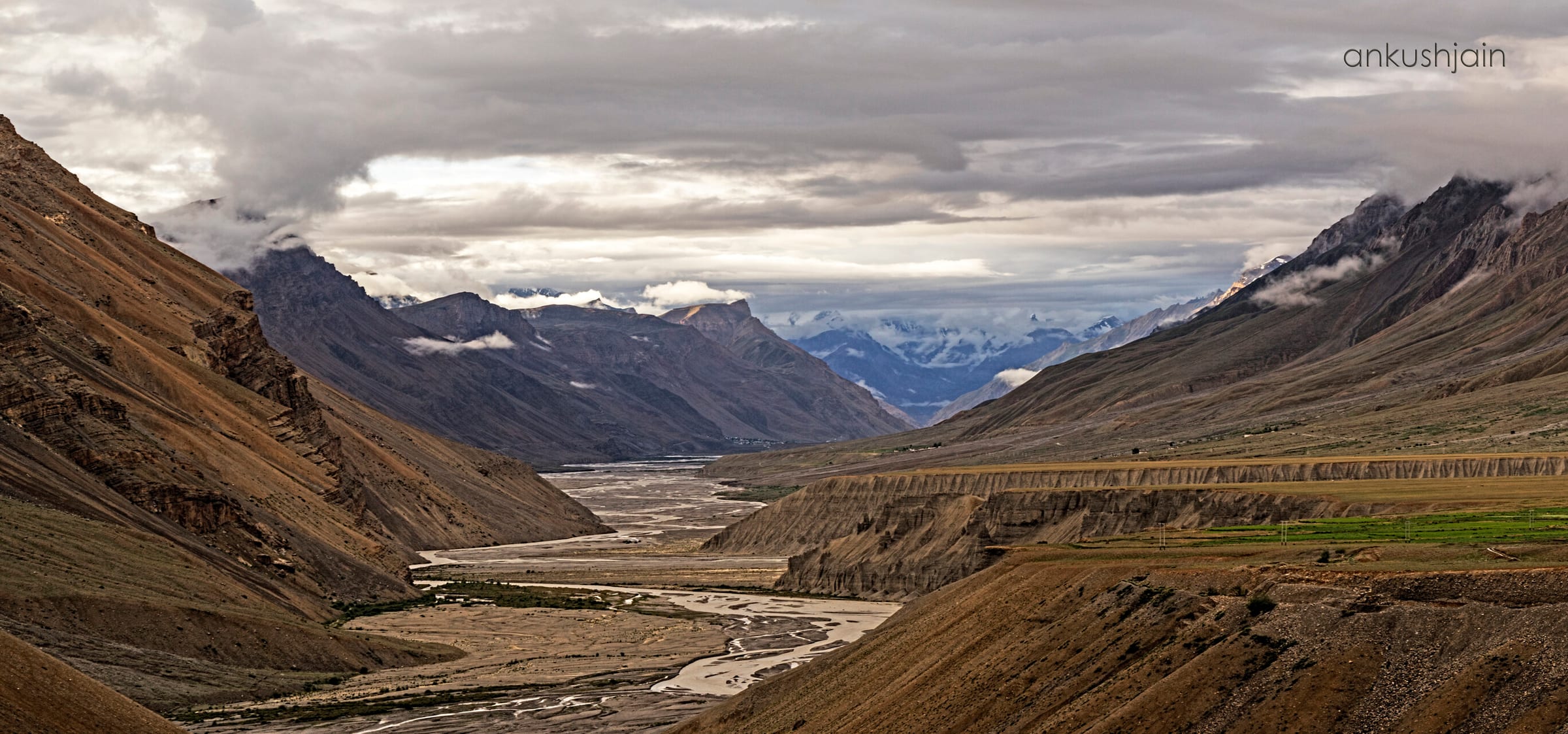 A dirt road switchbacking up the side of a steep mountain